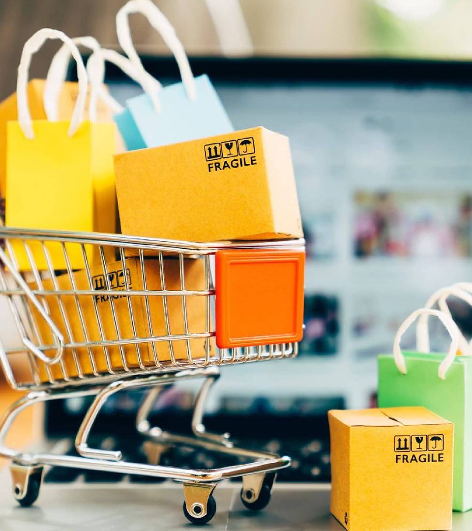 A small shopping cart filled with colorful shopping bags